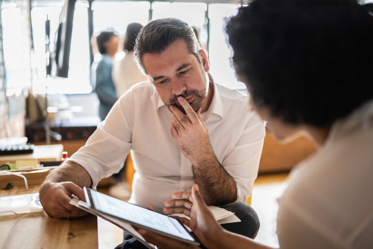 Manager looking over sample timesheets to choose between Clockify vs. Toggl