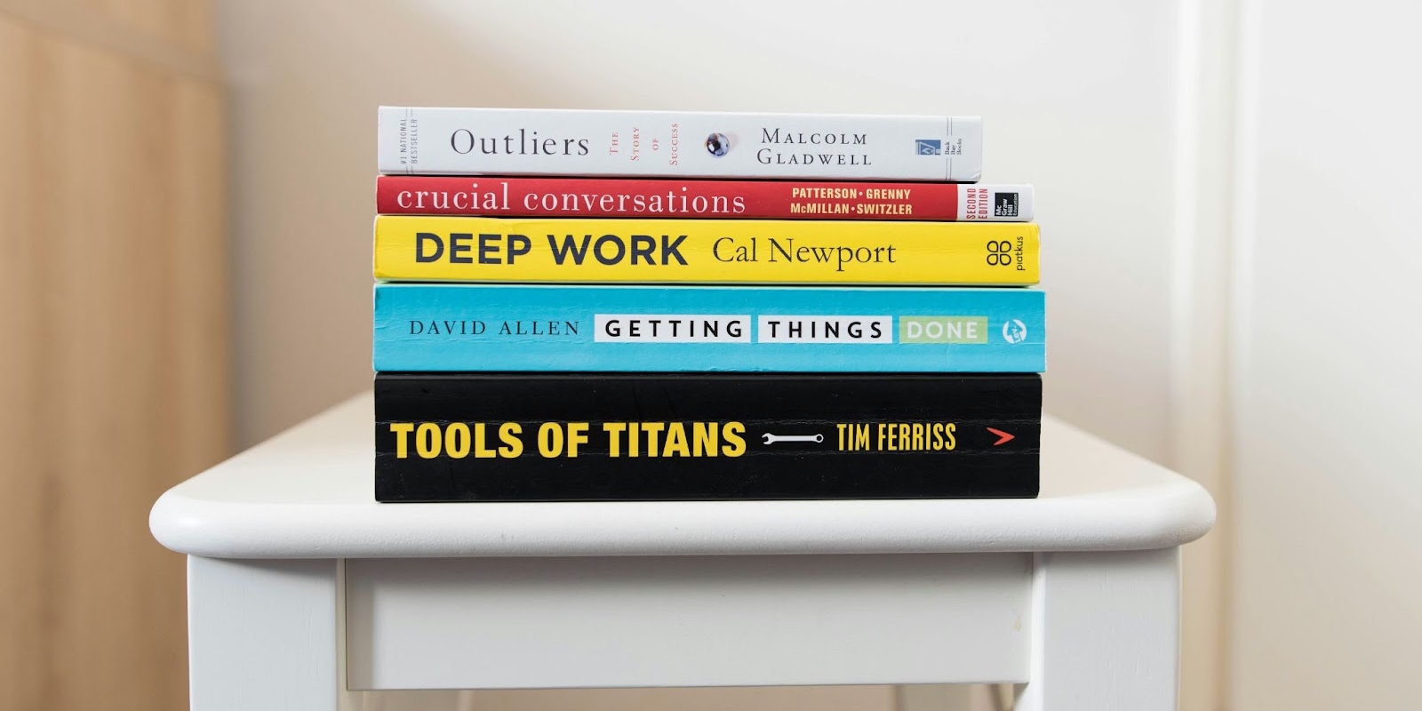 A stack of books with Deep Work by Cal Newport