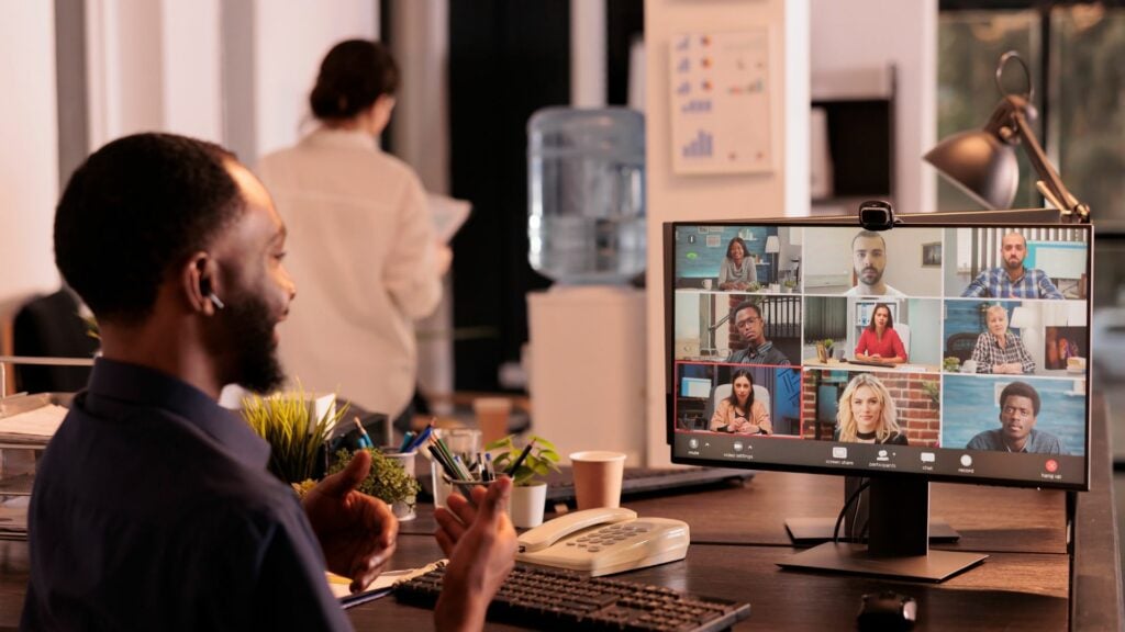 Man smiling on a video call with his team