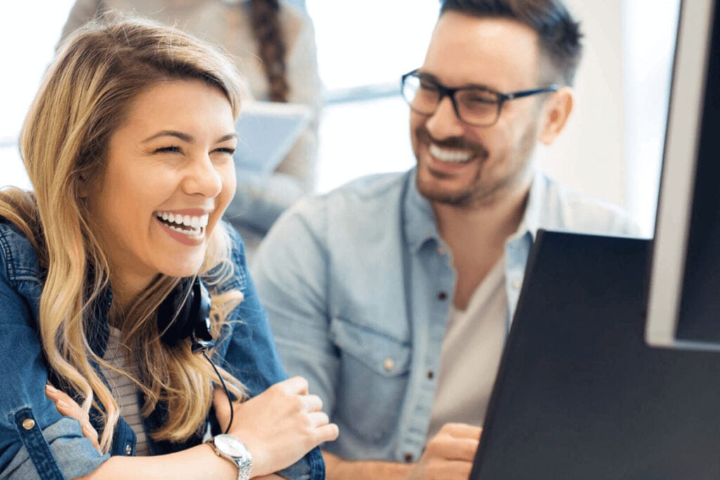 Image showing two team members smiling and having a conversation.